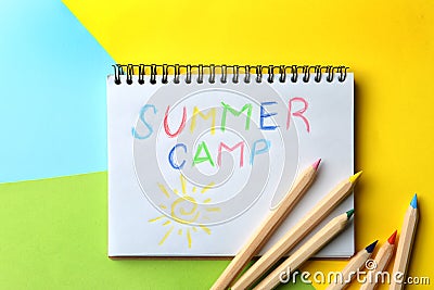 Notebook with written text SUMMER CAMP and different pencils on color background Stock Photo