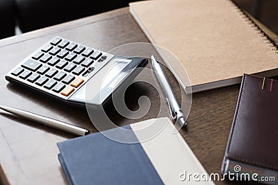 Notebooks, pens and calculator on wood table Stock Photo