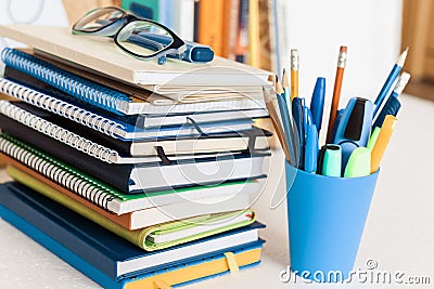 Notebooks piles, stack of books education back to school background, textbooks, glasses and pencils in plastic holder with copy Stock Photo