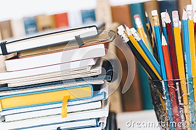 Notebooks piles, stack of books education back to school background, textbooks and pencils in plastic holder with copy space for Stock Photo