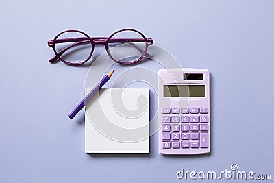 Notepad, colored pencil, calculator, glasses on purple background Stock Photo