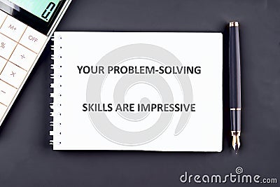 A notepad displays an encouraging message about problem-solving skills, positioned alongside a calculator and a pen Stock Photo