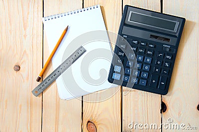 Notepad for entries with a calculator. pencil and ruler on a wooden table. Stock Photo