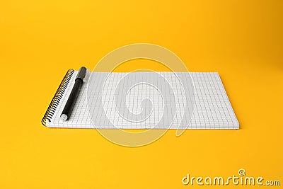 Notepad with erasable pen on yellow background Stock Photo