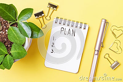 Notepad with the inscription plan on yellow background close-up top view. Stock Photo