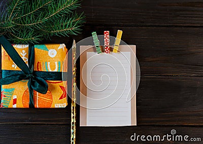 Notepad lays on the wooden background to make a list to do things or list of presents for friends and family. New year Stock Photo