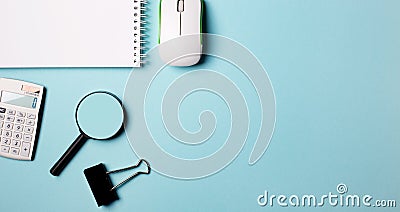 Notepad, magnifier, computer mouse and white wrist watch on a blue background. Place to insert text. Flat lay Stock Photo