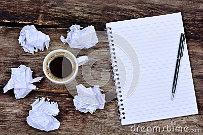 Notepad with pen coffee and crumpled paper on desk Stock Photo