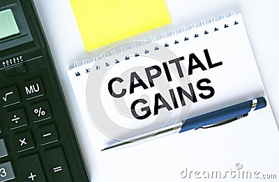 Notepad with text Capital Gains. Calculator, pen and stickers Stock Photo
