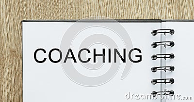 Notepad with text COACHING on wooden deskt. Business and finance concept Stock Photo