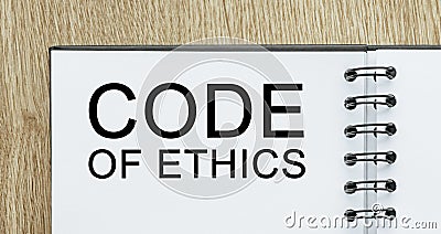 Notepad with text Code of Ethics on wooden deskt. Business and finance concept Stock Photo