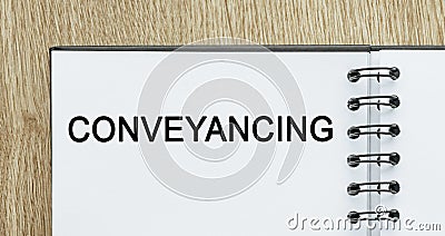 Notepad with text Conveyancing on wooden deskt. Business and finance concept Stock Photo