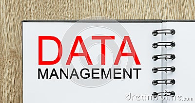 Notepad with text DATA MANAGEMENT on wooden deskt. Business and finance concept Stock Photo