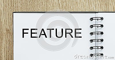 Notepad with text FEATURE on wooden deskt. Business and finance concept Stock Photo