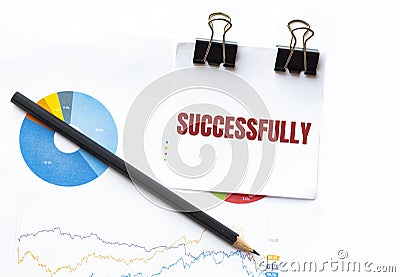 Notepad with text SUCCESSFULLY on business charts and pen Stock Photo