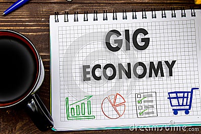 notes GIG ECONOMY on the office table with tools. Concept with elements of infographics Stock Photo