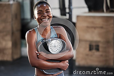 Nothing motivates me more than results. a fit young woman holding a weighing scale while at the gym. Stock Photo