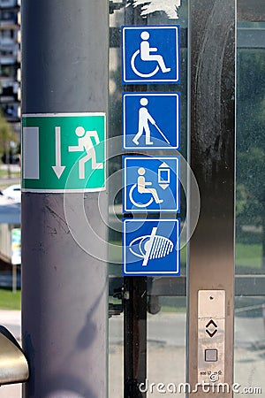 Notification stickers with symbols for disabled persons and visually impaired persons on glass elevator entrance platform Stock Photo