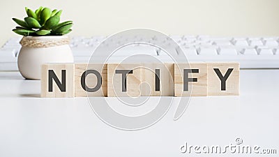 Notify word made with wooden blocks on background white keyboard Stock Photo