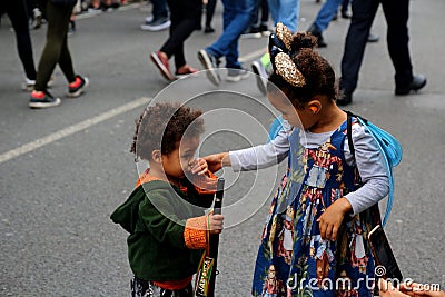 Notting Hill Carnival Mother with smartphone take picture of daughter in carnival costume Editorial Stock Photo