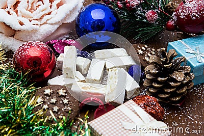 Nougat, traditional Spanish sweet for Christmas. sweet almond nougat dark background with snow and fir decorations Stock Photo