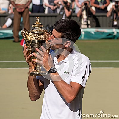 Novac Djokovic, Serbian player, wins Wimbledon for the fourth time. In the photo he kisses his trophy on centre court. Editorial Stock Photo