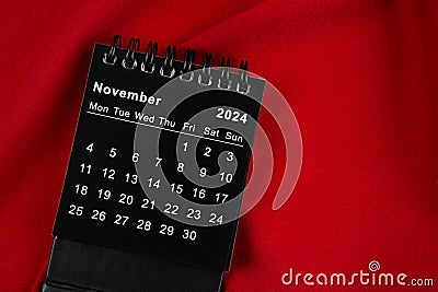 November 2024 Black spiral desktop calendar on textile Stock Photo