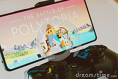 November 11, 2023, Brazil. The Battle of Polytopia logo is displayed on a smartphone screen, next to a Cartoon Illustration