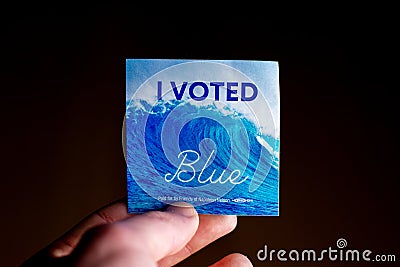 November 3, 2020 - Elkins Park, Pennsylvania: An Election Day Sticker Held by a Hand That Says I Voted Blue With a Wave in the Editorial Stock Photo