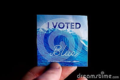 November 3, 2020 - Elkins Park, Pennsylvania: An Election Day Sticker Held by a Hand That Says I Voted Blue With a Wave in the Editorial Stock Photo
