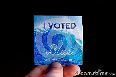 November 3, 2020 - Elkins Park, Pennsylvania: An Election Day Sticker Held by a Hand That Says I Voted Blue With a Wave in the Editorial Stock Photo