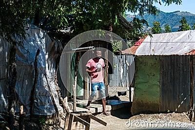 Dramatic image of a Haitian avocado farm worker preparing food for lunch Editorial Stock Photo