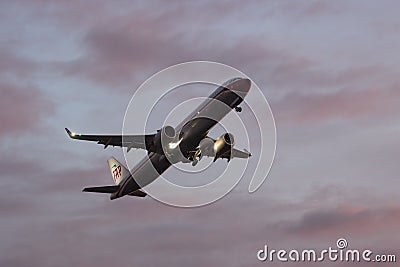 30 November 2022 PORTUGAL, LISBON: a large plane gains altitude in a purple sky Editorial Stock Photo