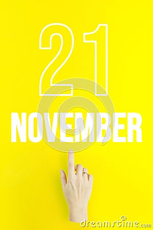 November 21st . Day 21 of month, Calendar date.Hand finger pointing at a calendar date on yellow background.Autumn month, day of Stock Photo