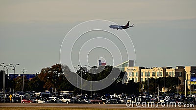 Plane coming in for a landing over building and Texas flag. Editorial Stock Photo