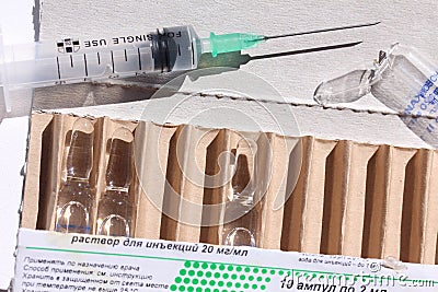 Novocaine in ampoule in the box and syringe on the table. Editorial Stock Photo