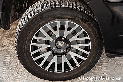 Black Dodge Ram with an engine of 5.7 liters front wheel view on the car parking with snow background Editorial Stock Photo