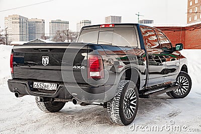 Black Dodge Ram with an engine of 5.7 liters rear view on the car parking with snow background Editorial Stock Photo