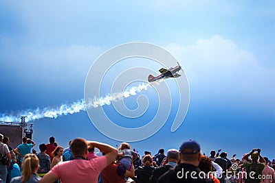 Mochishche airfield, local air show, yak 52 on blue sky with clouds background and many viewers, people watch aviashow Editorial Stock Photo