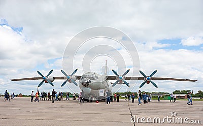 Civilians view large military transport aircraft AN-12 bk Editorial Stock Photo