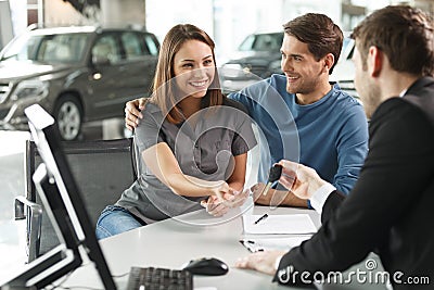 Now her dream comes true. Car salesman giving the key of the new Stock Photo
