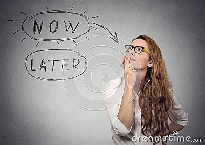 Now or later. Woman thinking looking up. Human face expression Stock Photo