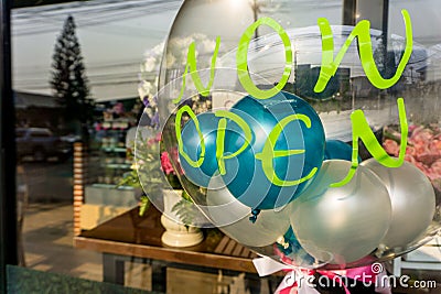 `Now Open` sticker on transparent balloon with other small colourful balloons inside. Stock Photo