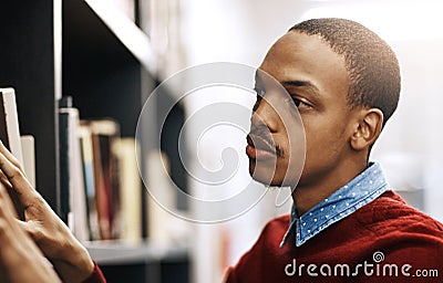 Now wheres that book I need...a university student looking for a book in the library at campus. Stock Photo