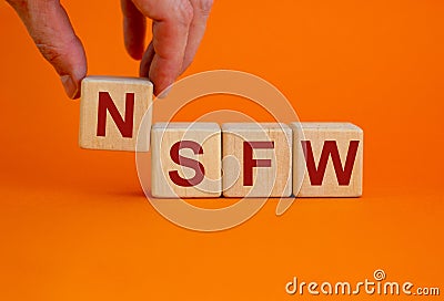 NSFW - not safe for work symbol. Wooden cubes with the word `NSFW - not safe for work` on beautiful orange background, copy spac Stock Photo