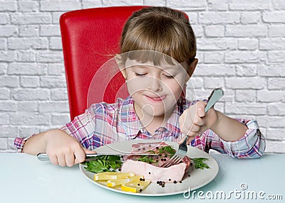 Nuce baby eats a big steak Stock Photo