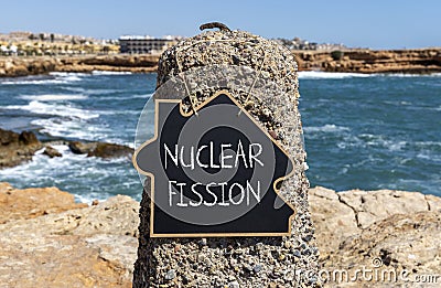 Nuclear fission symbol. Concept words Nuclear fission on beautiful black chalk blackboard. Chalkboard. Beautiful stone sea sky Stock Photo