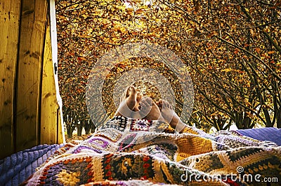 Nude feet people relaxing with autumn view outside a little cozy van - couple relaxing and sleeping together with love and Stock Photo