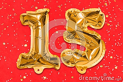 The number of the balloon made of golden foil, the number fifteen on a red background with sequins. Stock Photo