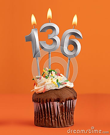 Number 136 candle - Birthday cupcake on orange background Stock Photo